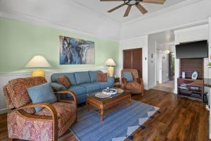 a living room with a blue couch and a table at Quiet Kiahuna plantation , New Remodel with AC in Koloa