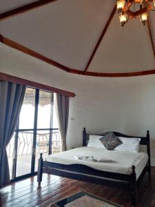 a bedroom with a bed and a large window at VILLA MARMARINE BEACH RESORT & RESTAURANT in Siquijor
