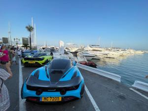 a group of expensive cars parked next to the water at Marbella Deluxe Rooms in Royal Cabopino Townhouse in Marbella