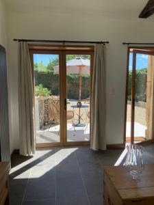 an open door to a patio with an umbrella at Les Ombrieres in Porcheresse