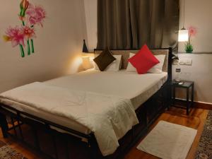 a bedroom with a bed with red and black pillows at River Ranch in Saralgaon