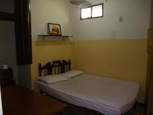 a small bedroom with a bed and a window at Villa Celeste in Guayaquil