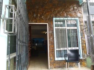 a door to a stone building with a black chair at Villa Celeste in Guayaquil