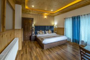 1 dormitorio con 1 cama y suelo de madera en HOTEL CHANTSA, en Leh