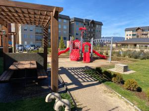 a playground with a red slide in a park at Departamento para 5 personas in Villarrica