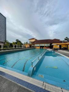 a large swimming pool with a building in the background at A'Famosa Condo D'Savoy, Slumber Family Homestay Mslim guest only in Kampong Pulau Sebang