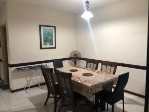 a dining room with a table with chairs and a light at A'Famosa Condo D'Savoy, Slumber Family Homestay Mslim guest only in Kampong Pulau Sebang