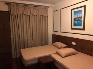 a bedroom with two beds and a window at A'Famosa Condo D'Savoy, Slumber Family Homestay Mslim guest only in Kampong Pulau Sebang +24 photos
