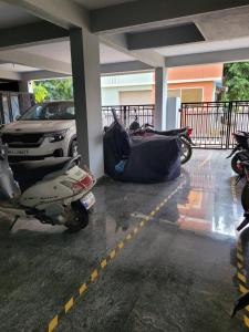 motocykl zaparkowany na parkingu z samochodem w obiekcie RV backpackers w mieście Bengaluru
