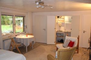 a room with a bed and a table and a kitchen at Ferienwohnung Hirschteich in Westensee