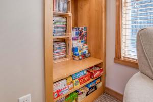 a book shelf filled with food and dvds at Pelicans Nest - Meredith Lodging in Pacific City