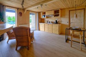 uma cozinha com pisos em madeira, uma mesa e cadeiras em La tanière em Chaudfontaine