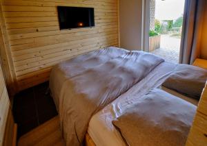 two beds in a room with a tv on a wall at La tanière in Chaudfontaine