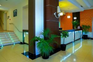 a lobby with two potted plants in a building at Central Park Baku in Baku