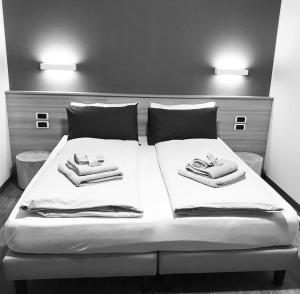 una camera da letto con un letto e asciugamani di B&B A fil di cielo a Val Masino