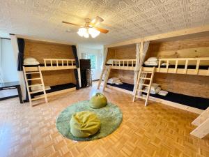 a room with three bunk beds and a rug at ヴィラYukara緑屋 in Nanae
