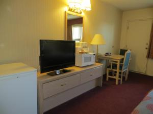 a small room with a desk and a television at Ramada Limited Calgary in Calgary