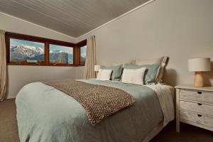 a bedroom with a bed with a view of mountains at Kanuka Terrace - Luxury Strawbale House in Kaikoura