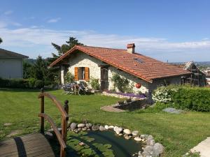 a small house with a pond in front of it at Le Grangeon 01 in Ambérieu-en-Bugey