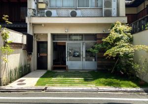 京都的住宿－Suzuki Guesthouse，一座有草地庭院的建筑的前门
