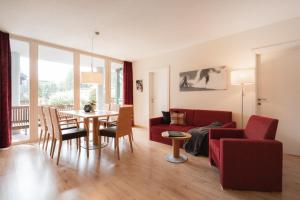 a living room with a red couch and a table at Annas Garten in Serfaus