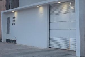 un garage bianco con porta su un edificio di Condomínio tranquilo a Boa Vista