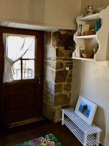 une chambre avec une porte et une photo sur un banc dans l'établissement Gîte Maison Maitri, à Forgès