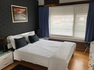 una camera con un letto bianco e due finestre di Crea Els a Westerlo