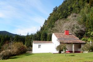 a white house with a red roof in a field at Furnas Lake Forest Living in Furnas