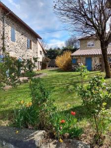 een tuin met een huis en bloemen in het gras bij Studio 45m2, à la campagne, à 15 mns du Puy en Velay in Lantriac