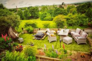 een tuin met stoelen en een tafel bij Alma Cliffe Guest House in Barnoldswick