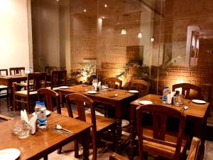 a restaurant with wooden tables and chairs with water bottles at Hotel Sabareesh Park in Madurai