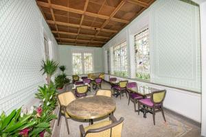 a room with a table and chairs and windows at Logis HOTEL DU PARC in Pont-à-Mousson