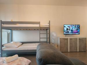 salon z kanapą i łóżkiem piętrowym w obiekcie Apartmán One To One w Štúrovie
