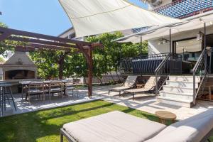 eine Terrasse mit einem Tisch, Stühlen und einem Grill in der Unterkunft Cukerina apartment with Whirpool & Sauna in Poreč