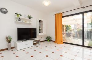 ein Wohnzimmer mit einem TV und Fliesenboden in der Unterkunft Cukerina apartment with Whirpool & Sauna in Poreč