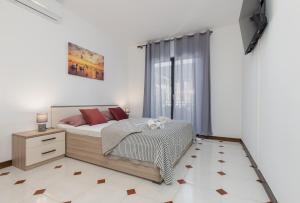 ein weißes Schlafzimmer mit einem Bett und einem Fenster in der Unterkunft Cukerina apartment with Whirpool & Sauna in Poreč