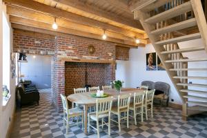 a dining room with a table and a brick wall at Vakantiewoning Oud Poperinghe in Poperinge