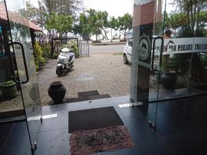 a scooter parked in front of a glass door at New Golden Bay Resort Weligama in Weligama