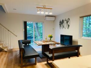 輕井澤的住宿－Compass Duo，一间带桌子、桌子和椅子的用餐室