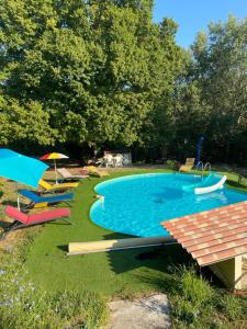 a large swimming pool with colorful chairs and umbrellas at Casa Ludese in Salernes