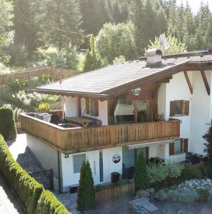 a large white house with a wooden roof at Chalet La Bosch, 7-persoons luxe eigen woning met privétuin in Ehrwald