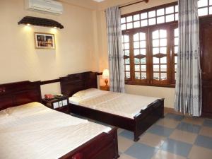 Un dormitorio con dos camas y una ventana. en Ca Ty Hotel, en Phan Thiet