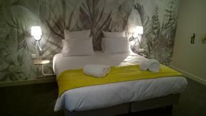 a bedroom with a bed with two towels on it at Aux Ateliers in Miserey-Salines +29 photos