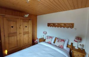 a bedroom with a bed and a wooden ceiling at Waldruhe in Jaun