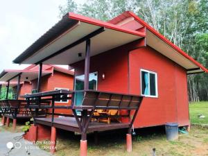 una casa rossa con un grande ponte di fronte di Lok Mun Bungalows a Ko Yao Noi