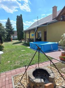 a backyard with a fire pit in front of a house at Rózsa Vendégház in Abádszalók