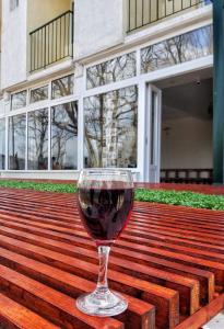 una copa de vino tinto en un banco de madera en BANJA SVETA NEDELA, en Katlanovo