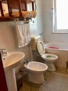 La salle de bains est pourvue de toilettes, d'un lavabo et d'une baignoire. dans l'établissement Apartmani Luka, à Korčula