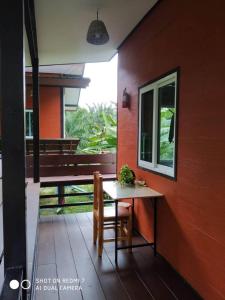 a table and chair on the side of a house at Lok Mun Bungalows in Ko Yao Noi
